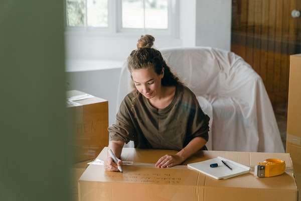 Conveyancing Client A client packs up her belongings into cardboard boxes in preparation for moving house