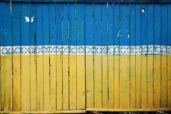 Ukrainian Flag An image of a fence with the Ukrainian flag painted on it