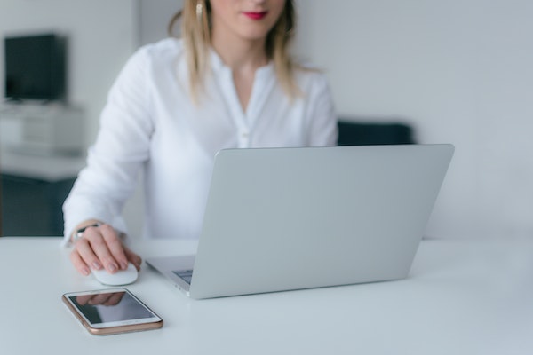 A woman works on a laptop at her desk in a bright and modern office