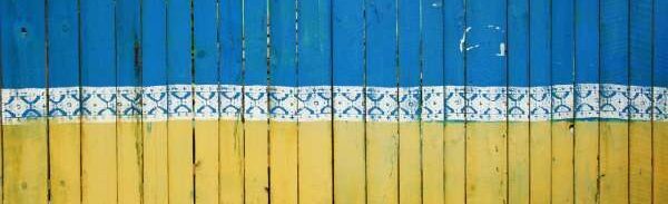 Ukrainian Flag An image of a fence with the Ukrainian flag painted on it