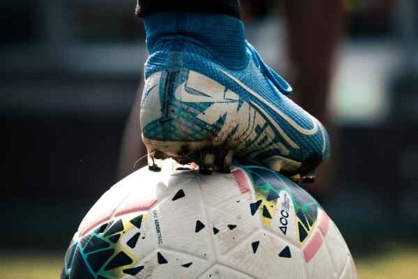 Rotherham United Football Club A closeup image of a football player resting their foot on a football