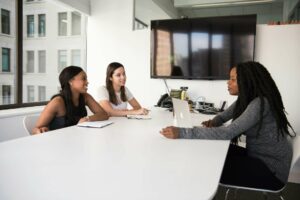 Three female colleagues have a meeting in a bright and modern office room