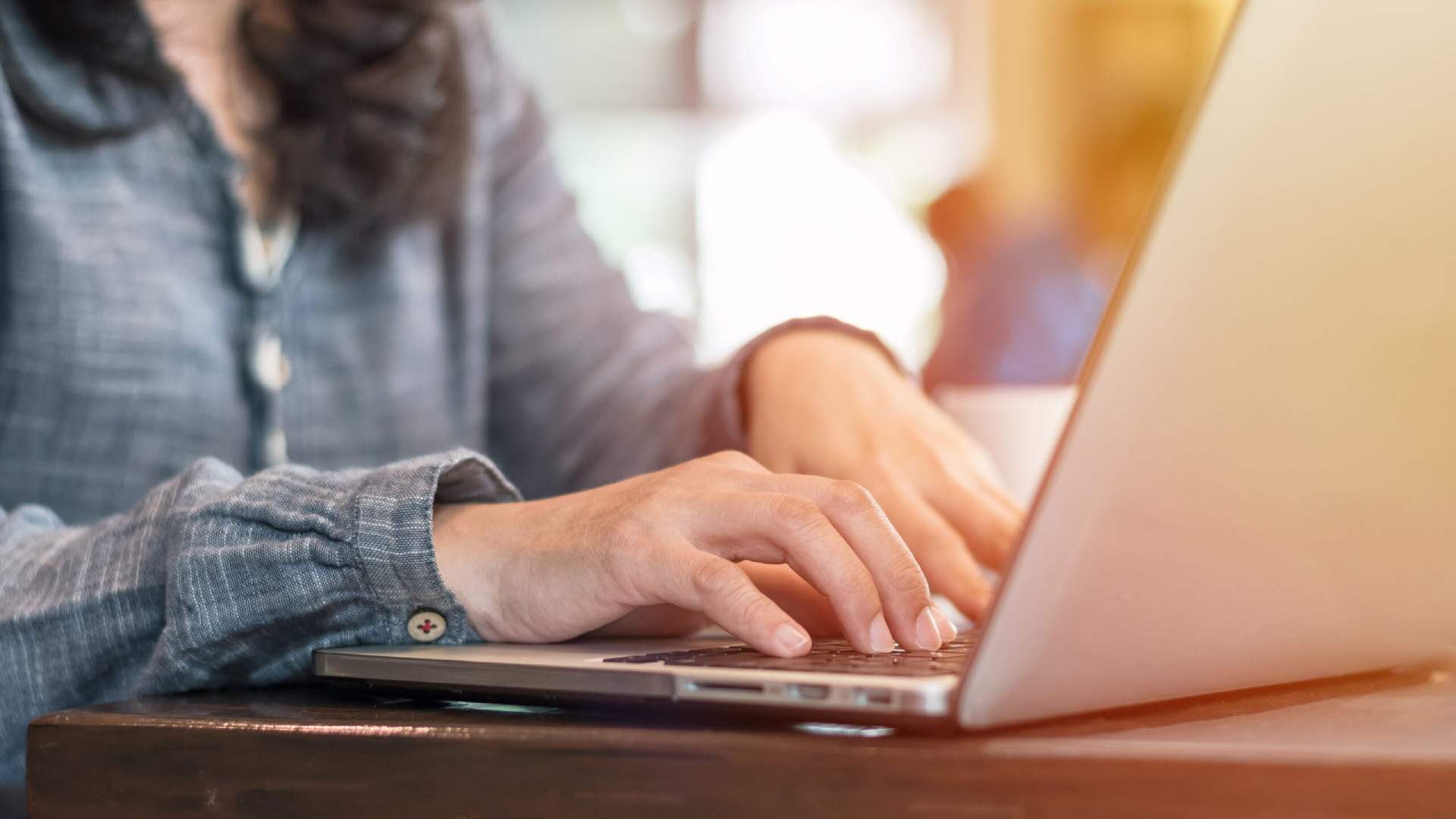 A closeup image of a legal professional working at a desk on her laptop.