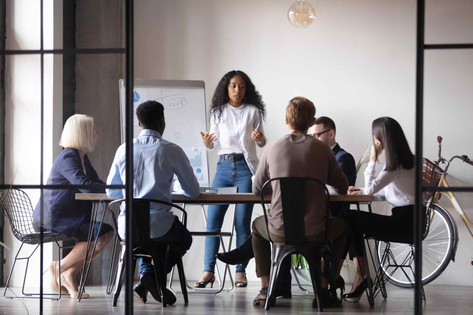 A young woman delivers a presentation to her colleagues