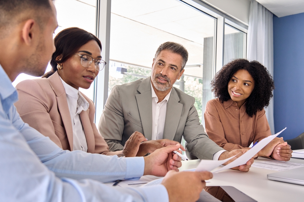 Business team in a meeting, discussing a document.