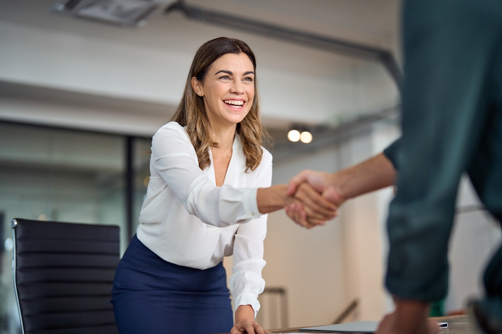Woman shaking hands in a meeting.