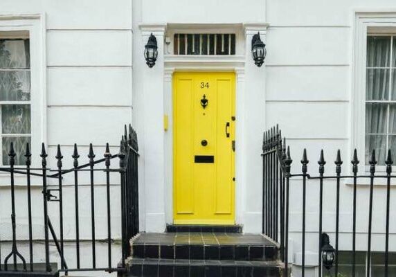 Umbrella Firm An image of a white building with a bright yellow front door