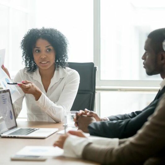 Legal Professional Meeting A legal professional explains a concept to her colleagues during a meeting