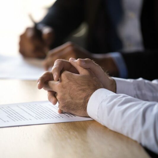 Legal professionals Two legal professionals sit at a desk and make notes during a meeting