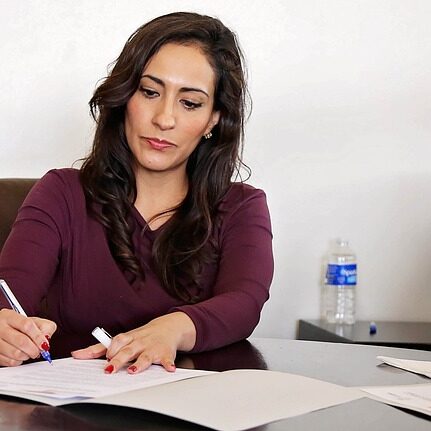 Solicitor A solicitor signs a legal document at her desk
