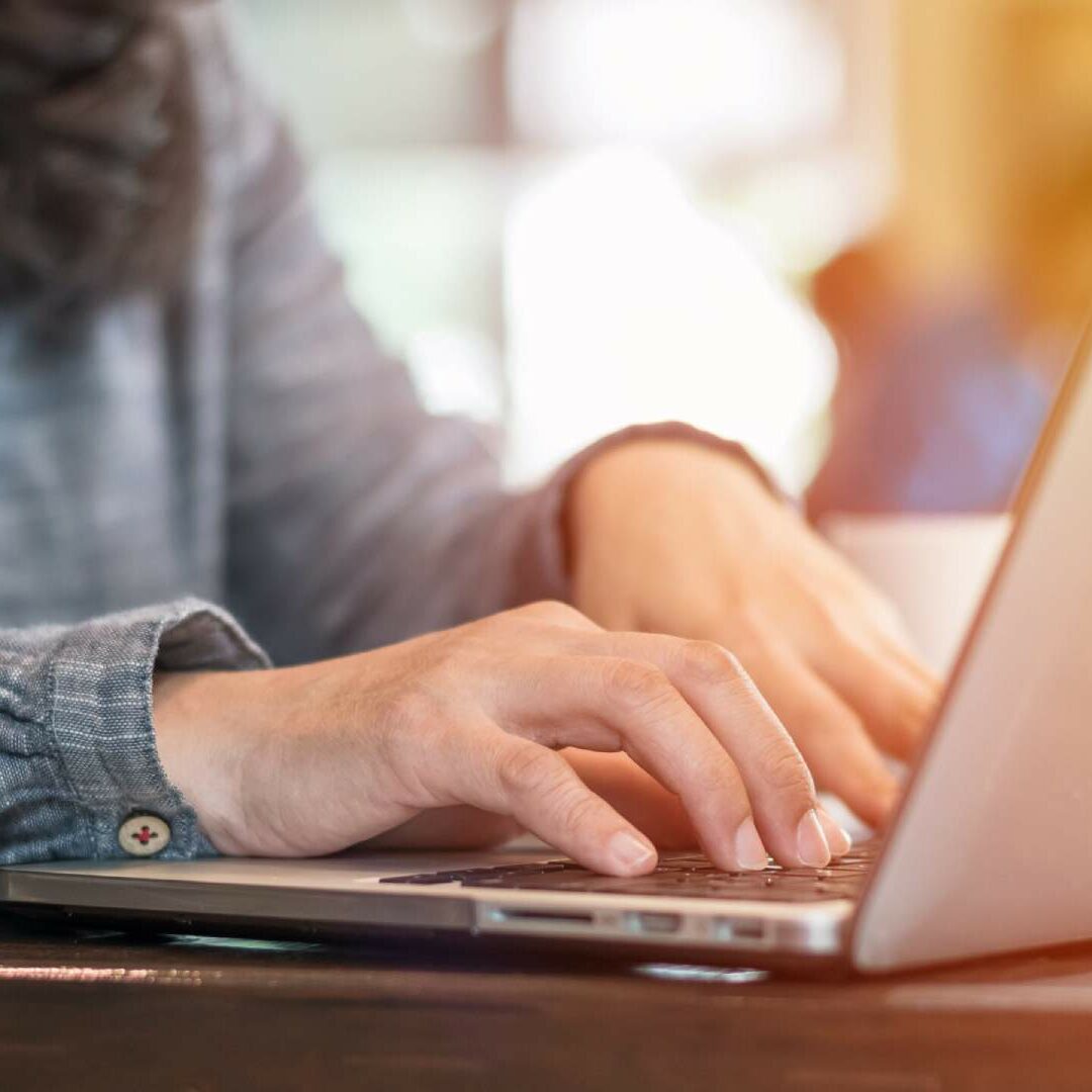 A closeup image of a legal professional working at a desk on her laptop.